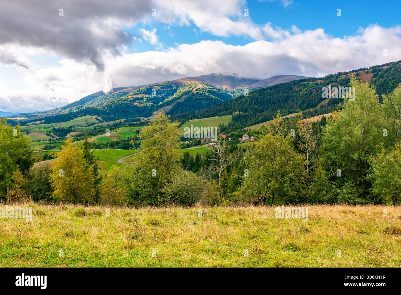 paesaggio montano all'inizio dell'autunno per i viaggi. paesaggio alpino con foresta colorata. splendida valle di campagna con colline ondulate. vista o Foto Stock