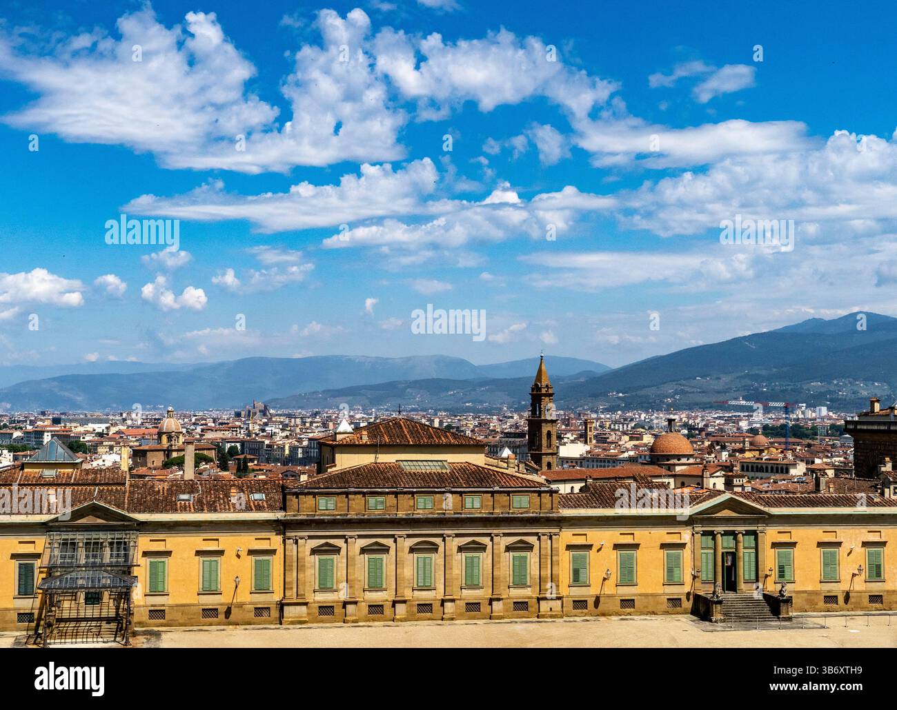 Una vista panoramica di Firenze, Italia, che mostra l'architettura storica e un cielo vibrante. Il primo piano presenta un grande edificio con terrazza, wh Foto Stock