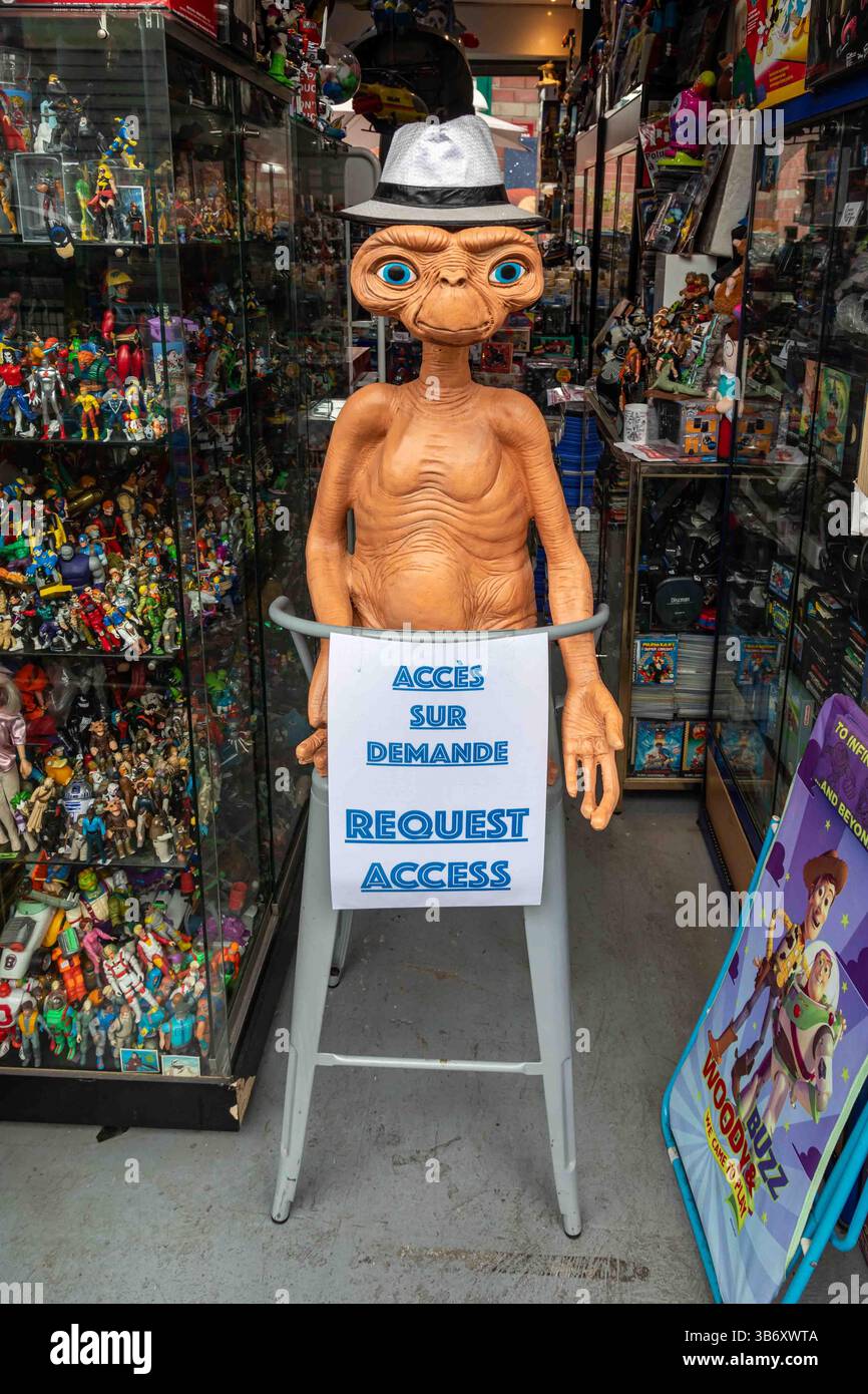 E.T. in plastica o personaggio extra-terrestre su un seggiolone di fronte a un negozio che vende oggetti da collezione al mercato delle pulci di Saint Ouen a Parigi, Francia Foto Stock