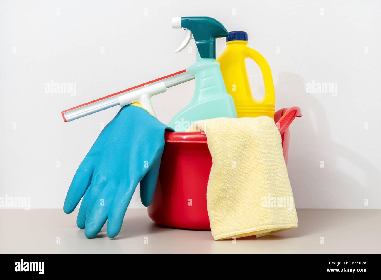 Prodotti per la pulizia in secchio, tra cui guanti, panno in microfibra, flacone spray e candeggina Foto Stock