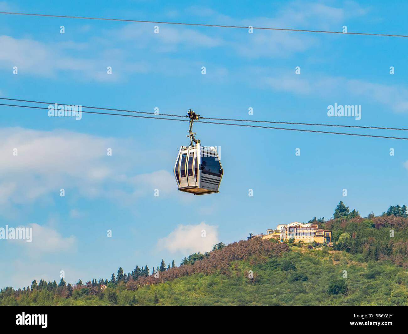 Moderne funivie che si spostano sopra Tbilisi, Georgia, con una vista panoramica della città. Un sistema di trasporto urbano unico e una popolare attrazione turistica Foto Stock