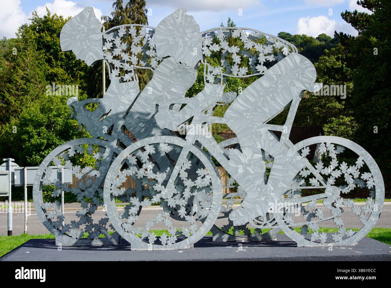 Vista ravvicinata di una scultura in metallo contemporanea raffigurante ciclisti, che celebra il ciclismo su strada e l'arte pubblica in Gran Bretagna. Dorking, Inghilterra Foto Stock