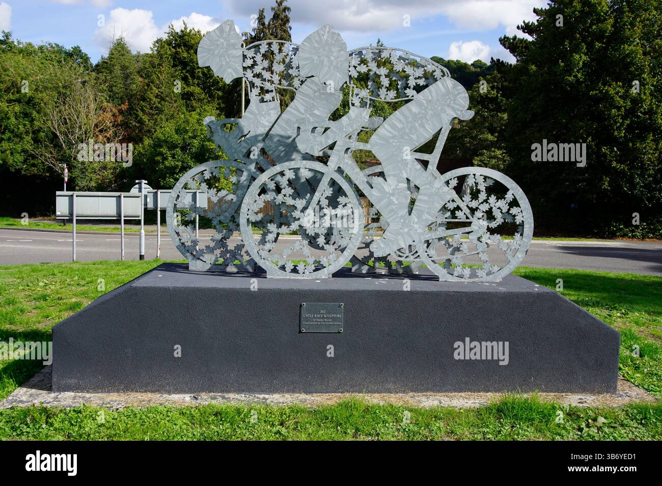 Scultura contemporanea in metallo di ciclisti in mostra in un parco pubblico, che celebra il patrimonio ciclistico britannico e lo sport all'aperto. Dorking, Inghilterra Foto Stock