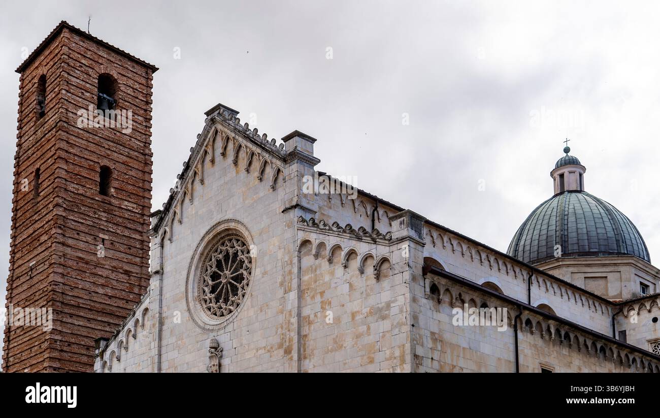 Vista ravvicinata di una chiesa storica con un campanile e una cupola. L'architettura presenta intricati lavori in pietra e una grande finestra circolare, se Foto Stock