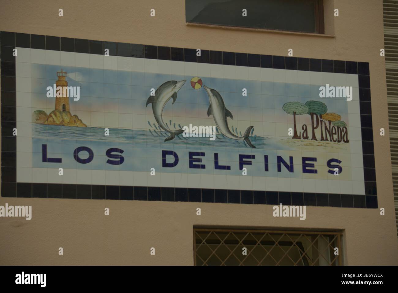 Cartello da parete in ceramica dipinto a mano “Los Delfines – la Pineda” raffigurante due delfini e un faro sulla Costa Dorada.Salou, Spagna Foto Stock
