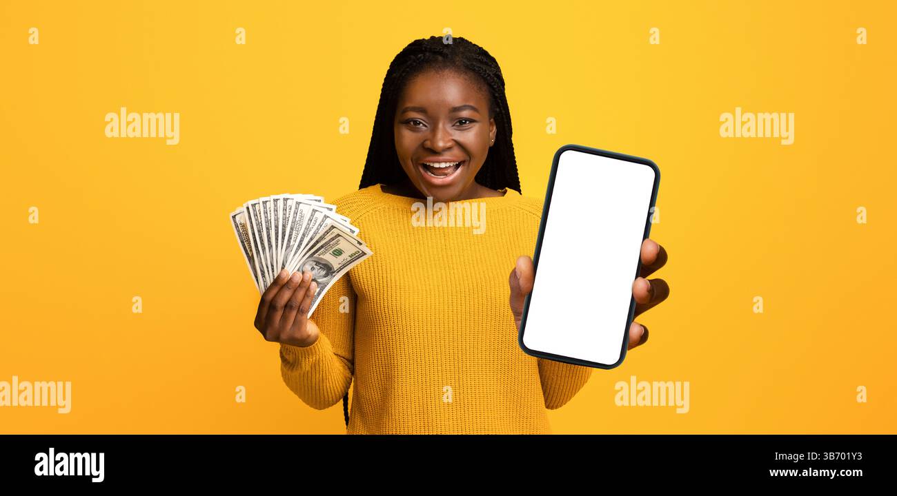 Concetto di cashback. La giovane donna eccitata che tiene in mano smartphone e Dollar Cash, ha ricevuto un bonus di grande denaro, esclamando con Joy, celebrando il successo, Standing Foto Stock