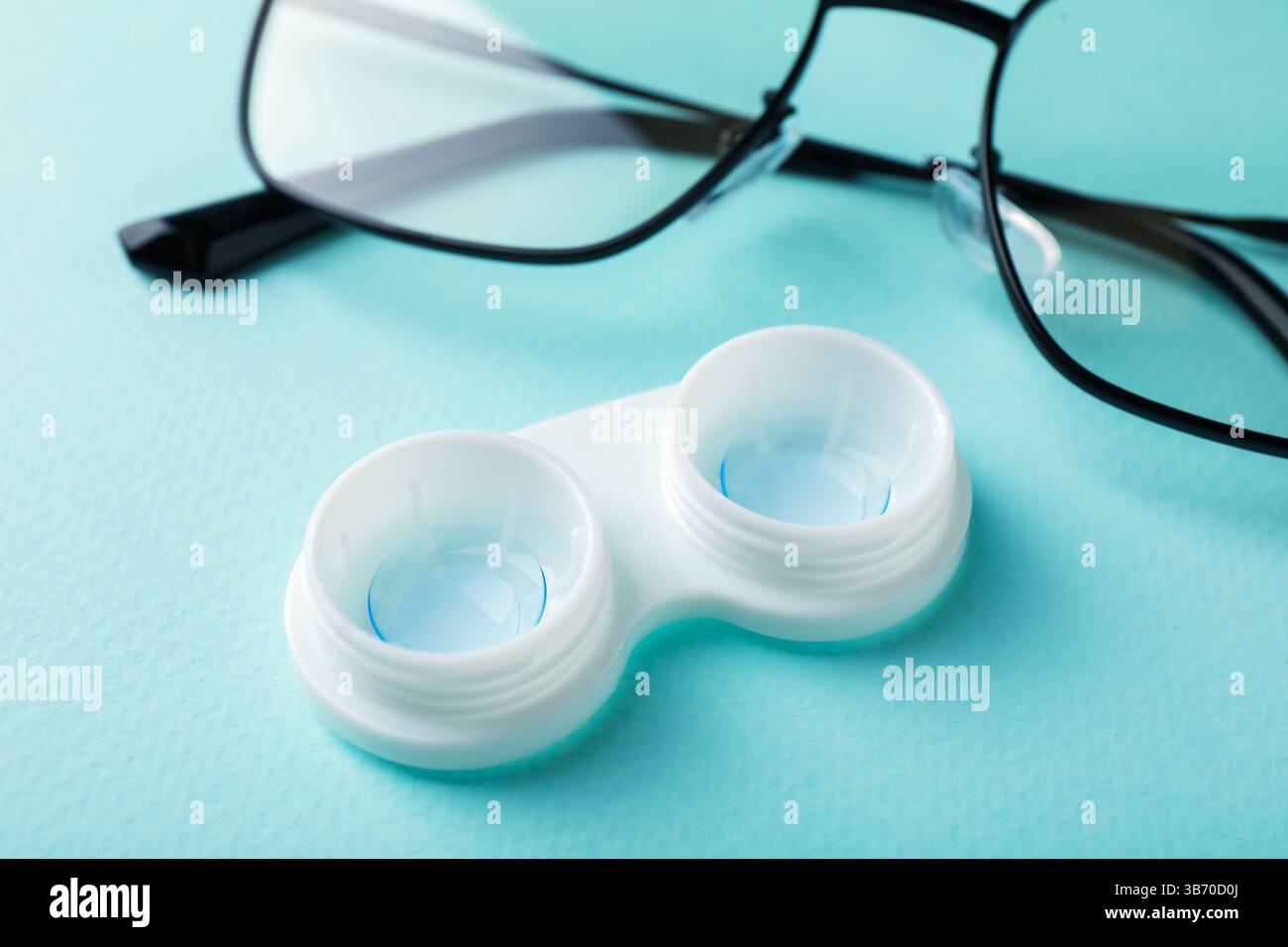 Lenti a contatto in astuccio e occhiali su sfondo turchese, primo piano Foto Stock