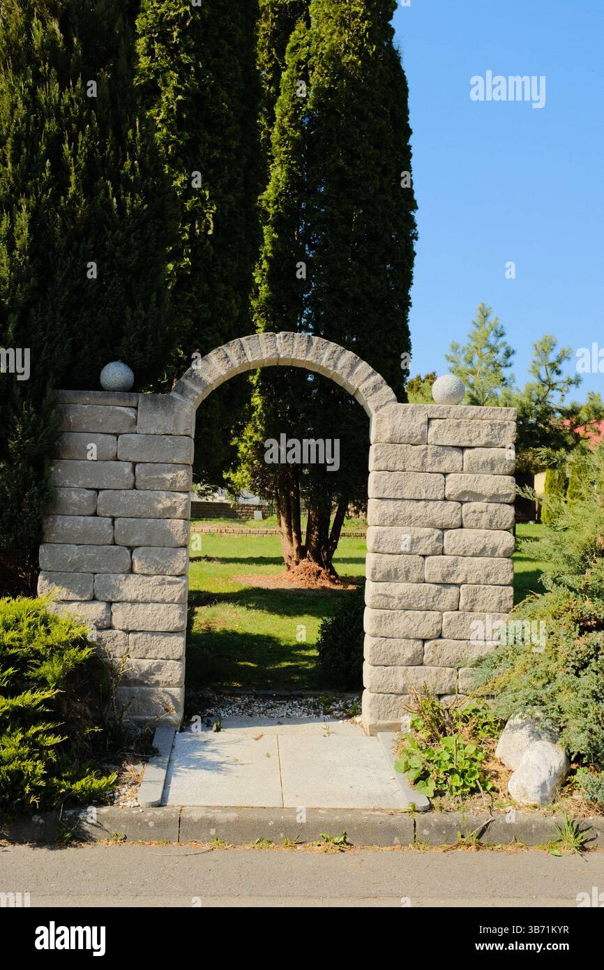 giardino del villaggio europeo decorato con statue bianche del coniglio pasquale e vegetazione primaverile sotto il cielo limpido. Foto di alta qualità Foto Stock