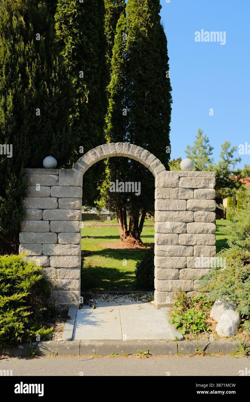 giardino del villaggio europeo decorato con statue bianche del coniglio pasquale e vegetazione primaverile sotto il cielo limpido. Foto di alta qualità Foto Stock