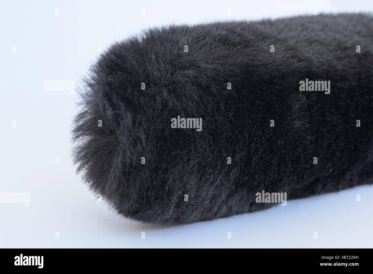primo piano di spazzola per cerchi in pelliccia sintetica nera in pelliccia sintetica, schermo antivento per microfono, protezione antivento Foto Stock