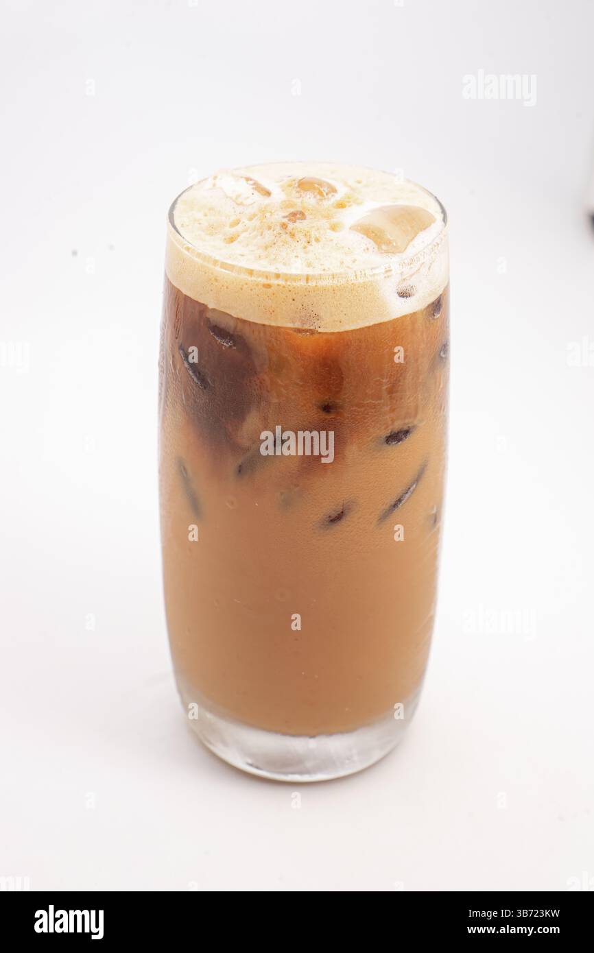caffè ghiacciato con crema e cubetti di ghiaccio servito in alto vetro trasparente con la parte superiore schiumosa fotografata su sfondo bianco. Foto di alta qualità Foto Stock