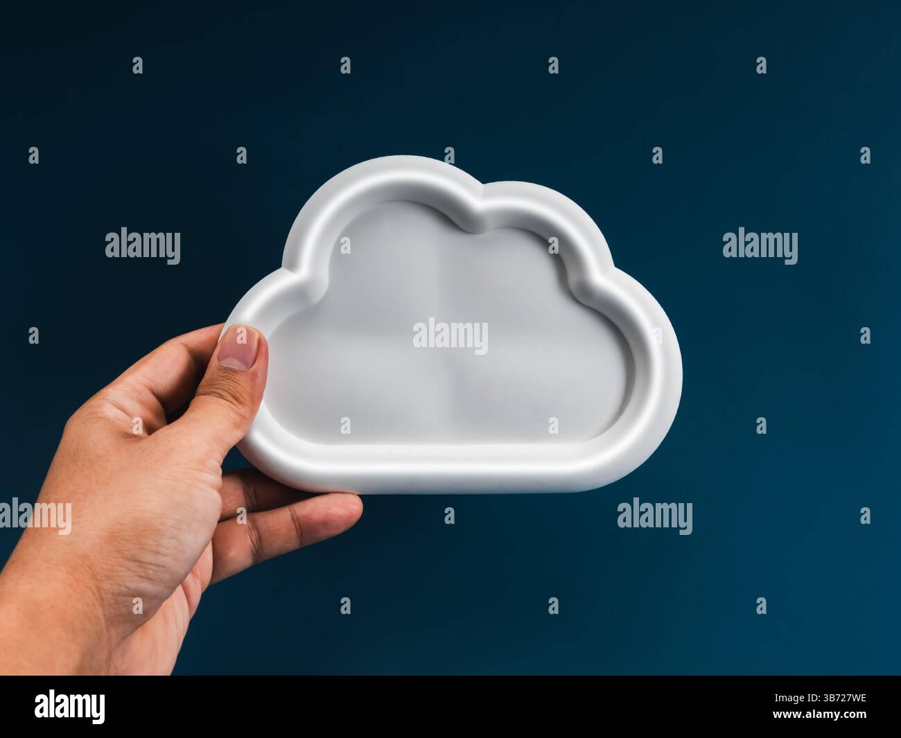 Tecnologia dell'infrastruttura di cloud computing, concetto di servizio di storage dei sistemi di dati. Nuvola bianca vuota con spazio, tenuta per mano da uomo d'affari, su blu scuro Foto Stock