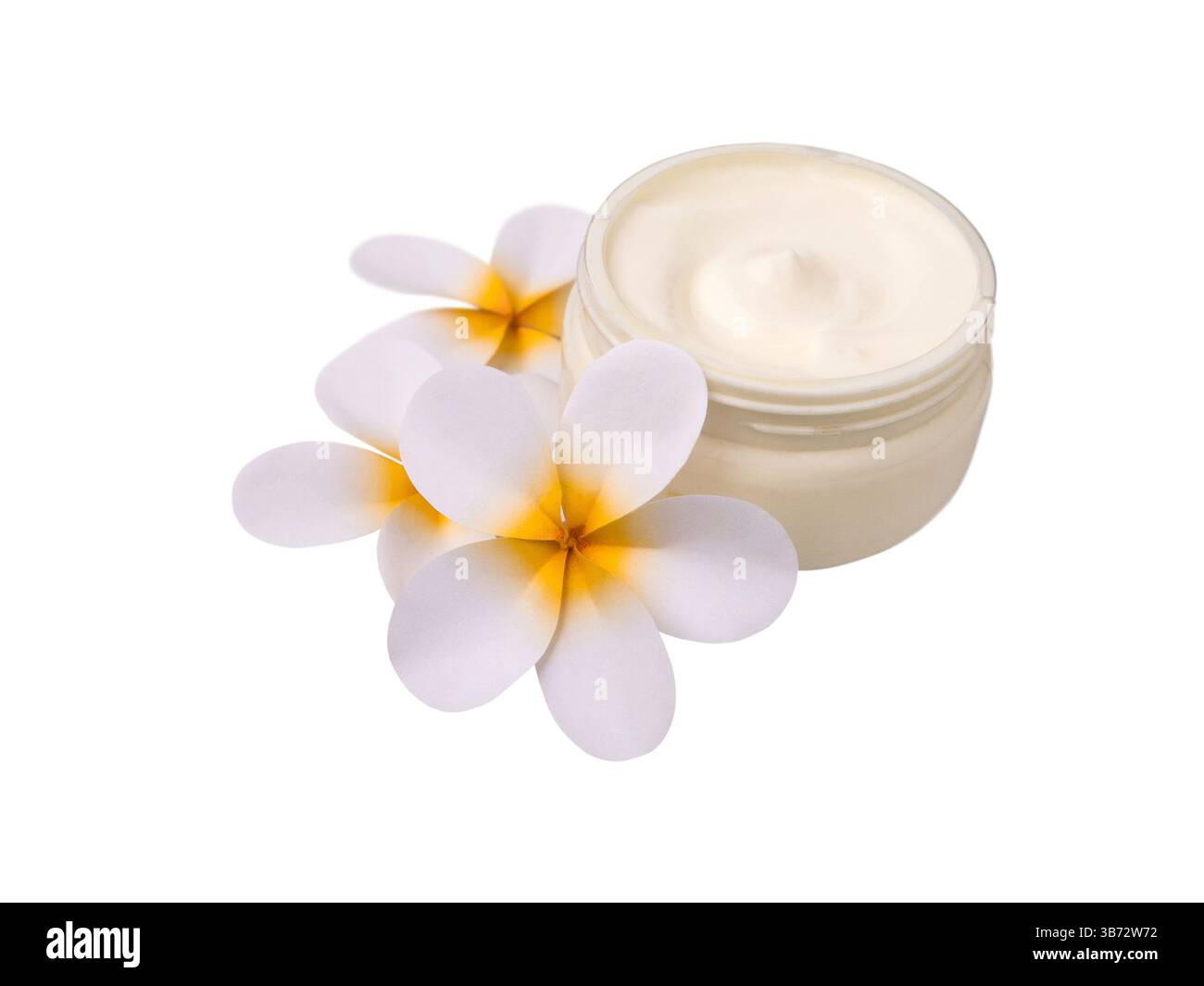 Vaso cosmetico riempito con crema idratante bianca circondato da fiori tropicali plumeria o frangipani isolati su sfondo bianco. Centro benessere, beauty farm Foto Stock
