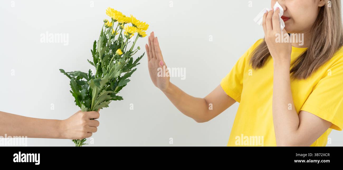 Allergie al polline, giovane donna asiatica starnuti in un fazzoletto o soffiare in una salvietta, allergica ai fiori primaverili selvatici o ai fiori in primavera. allerg Foto Stock