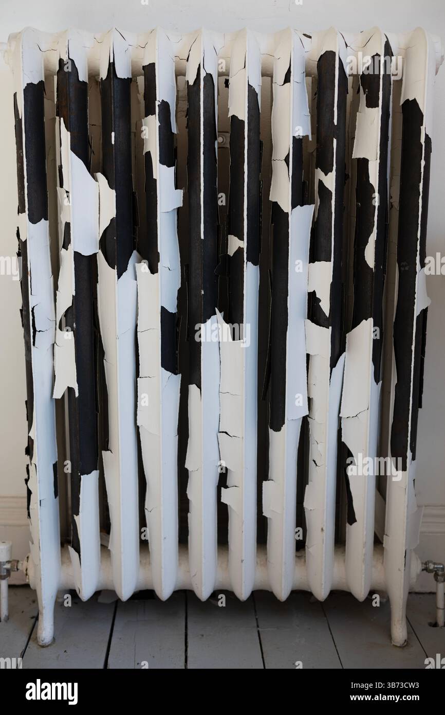 Rimozione della vernice su un radiatore Foto Stock