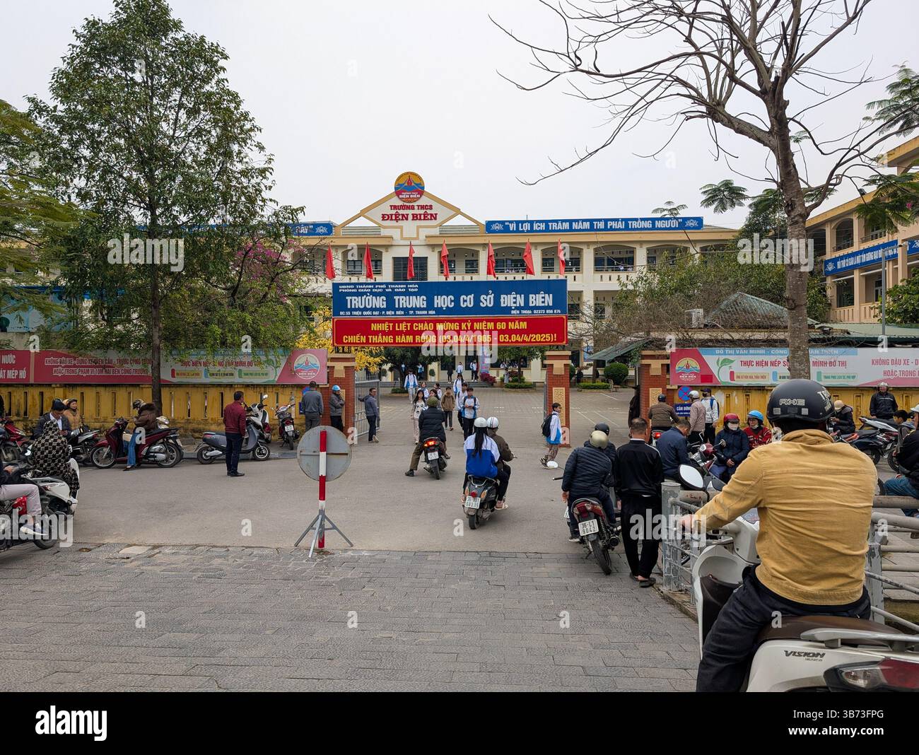 Gli studenti di una scuola media a Thanh Hoa, Vietnam, il 18 marzo 2025 lasciano la scuola dopo le lezioni. Gli alunni sono vestiti con uniformi bianche e blu. Foto Stock