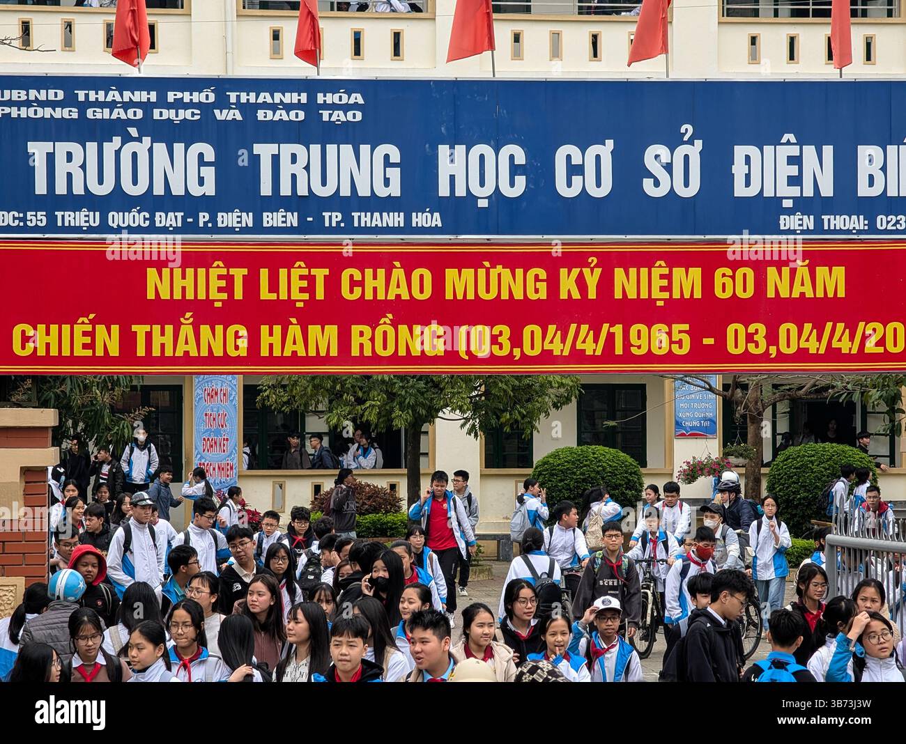 Gli studenti di una scuola media di Thanh Hoa, Vietnam, lasciano le loro classi dopo le lezioni il 18 marzo 2025, l'ingresso della scuola è abbellito da un divieto Foto Stock