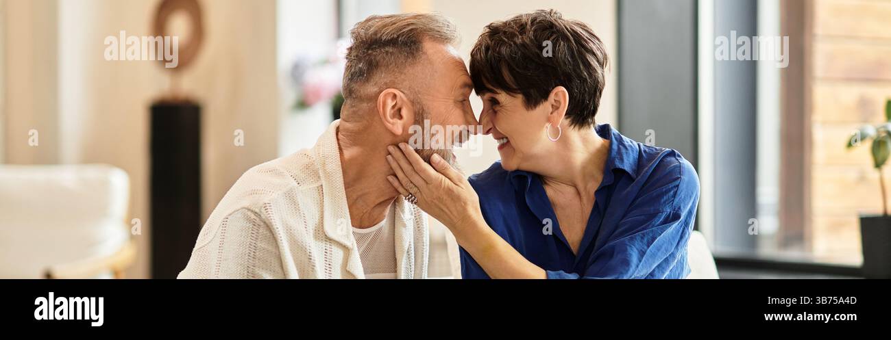 Una coppia di mezza età gode di un momento affettuoso insieme a casa, crogiolandosi nella felicità, striscione Foto Stock