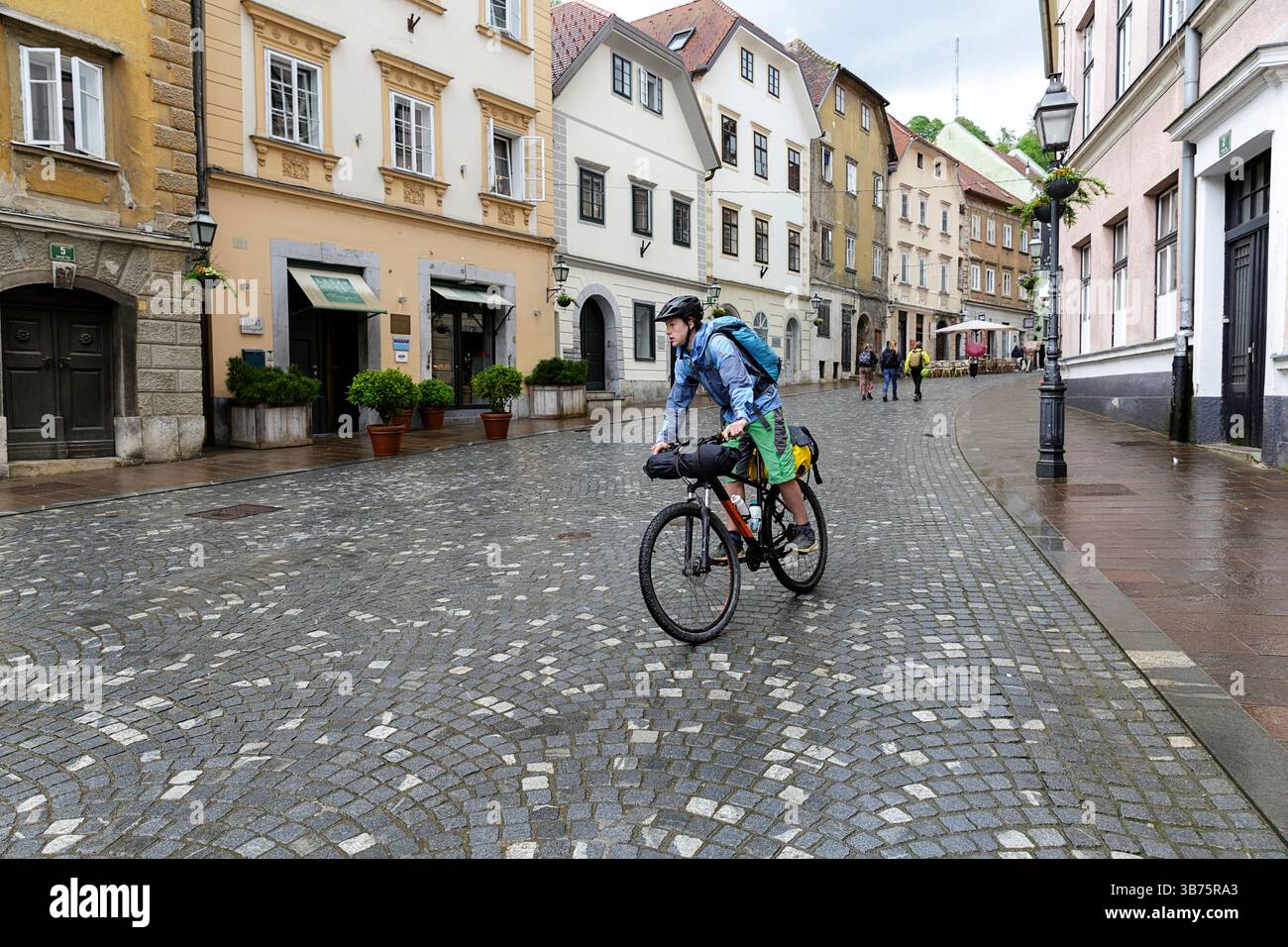 Adolescente in un viaggio in bicicletta per la Slovenia, ciclista in bicicletta intorno alla parte storica vecchia di Lubiana, in Slovenia, esplorando diverse attrazioni turistiche Foto Stock