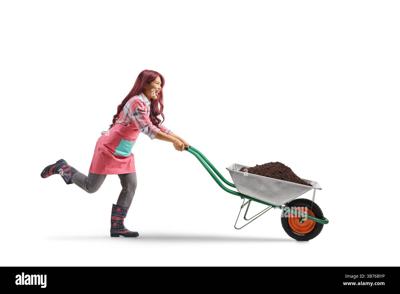 Giardiniere asiatica che spinge una carriola con la terra isolata su sfondo bianco Foto Stock