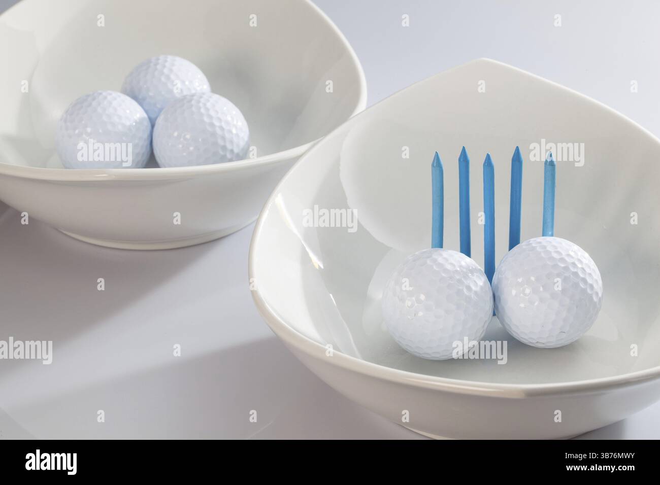 Due ceramiche bianche bocce e palline da golf Foto Stock