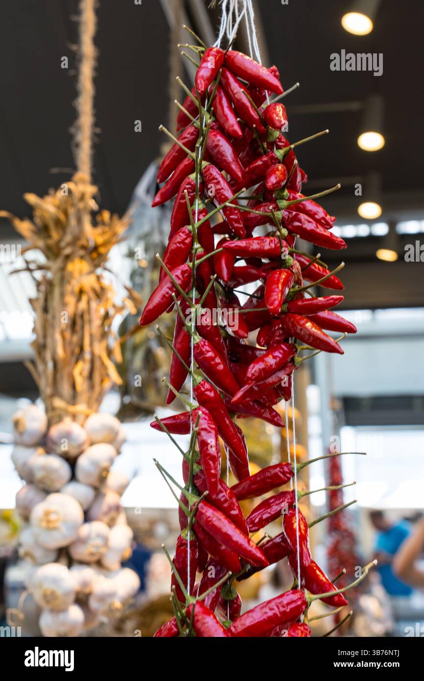 Fasci di peperoni rossi secchi piccanti appesi in un mercato agricolo in Portogallo Foto Stock