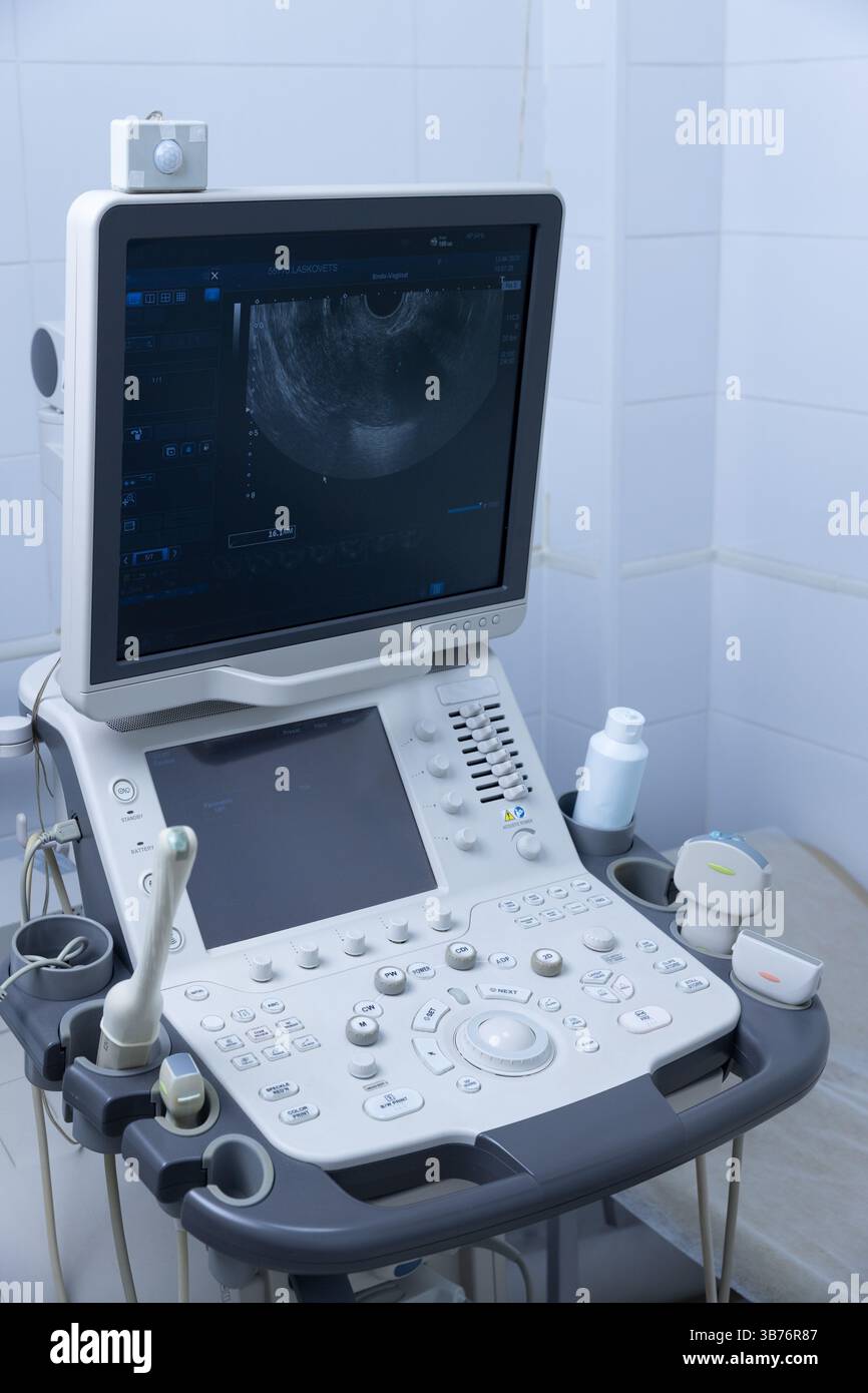 Questa macchina ecografica all'avanguardia presenta un ampio monitor che visualizza immagini dettagliate utilizzate per la diagnostica in ambito sanitario, concentrandosi sul ginocchio del paziente Foto Stock