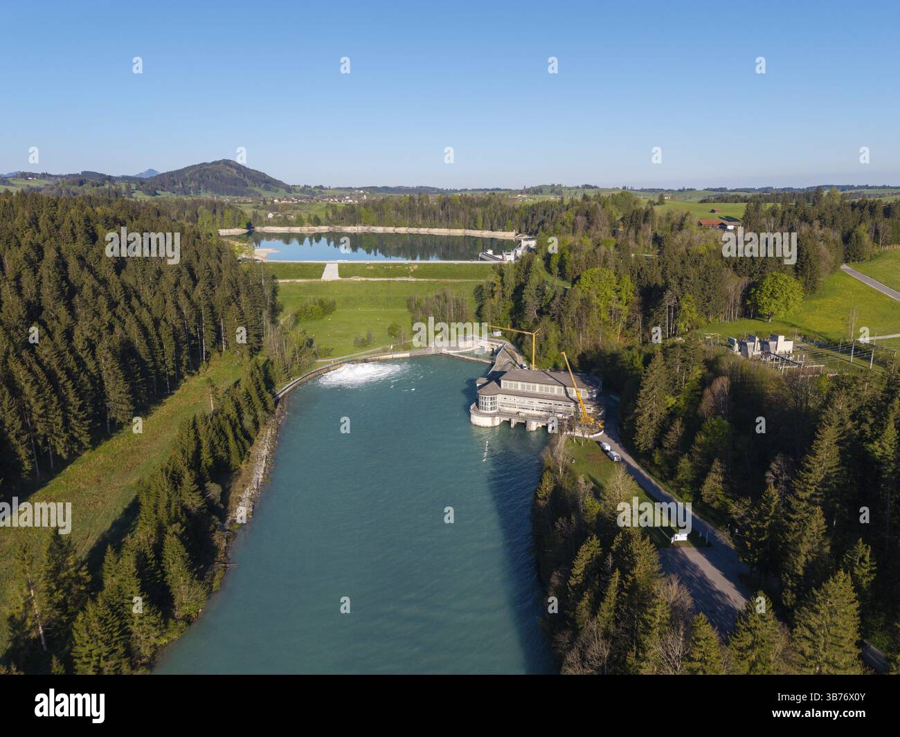 Vista aerea di un fiume che scorre attraverso un paesaggio boscoso con una strada di campagna, sbarramento di Lech a Forggensee, Lech, centrale elettrica, bacino idrico principale, inondazione Foto Stock