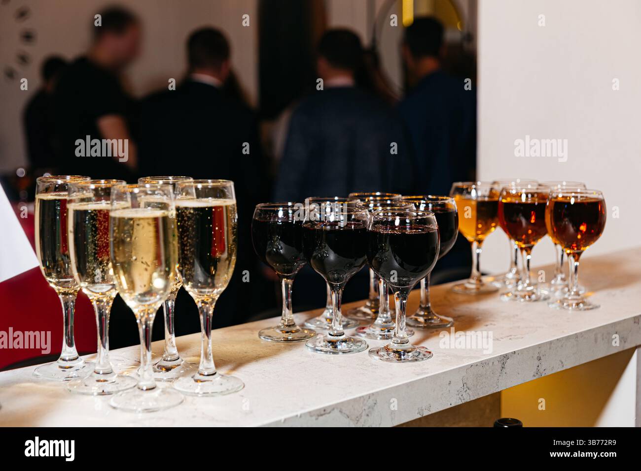 Selezione di vini, champagne e cocktail serviti su un bancone durante una riunione o una celebrazione con gli ospiti. Foto Stock