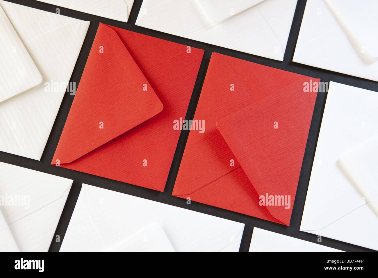 Composizione con buste bianche e rosse sul tavolo. Buste di colori diversi sul tavolo Foto Stock