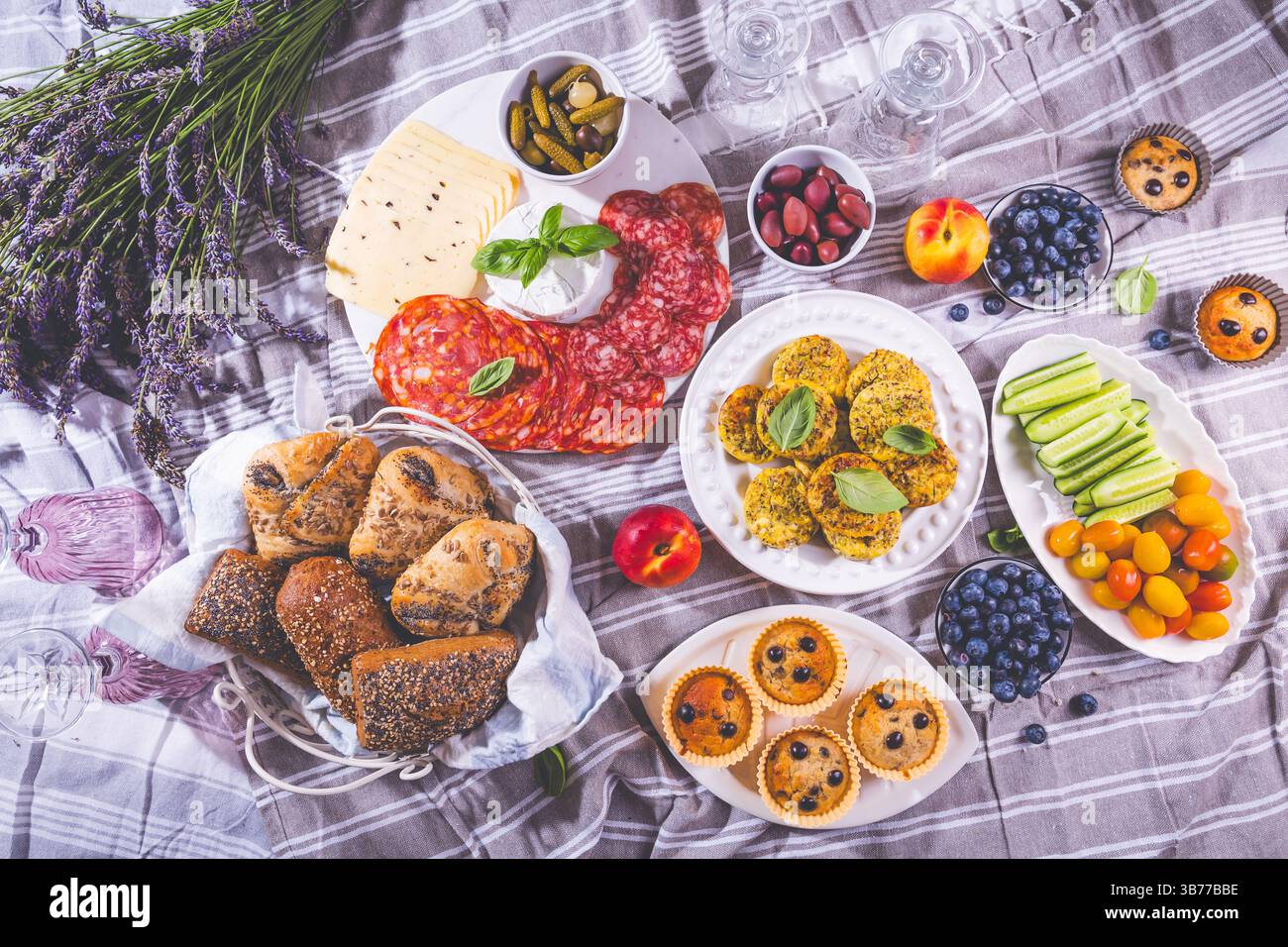 Picnic, antipasti e vassoio di formaggi e carne con muffin dolci e salati e frutta Foto Stock