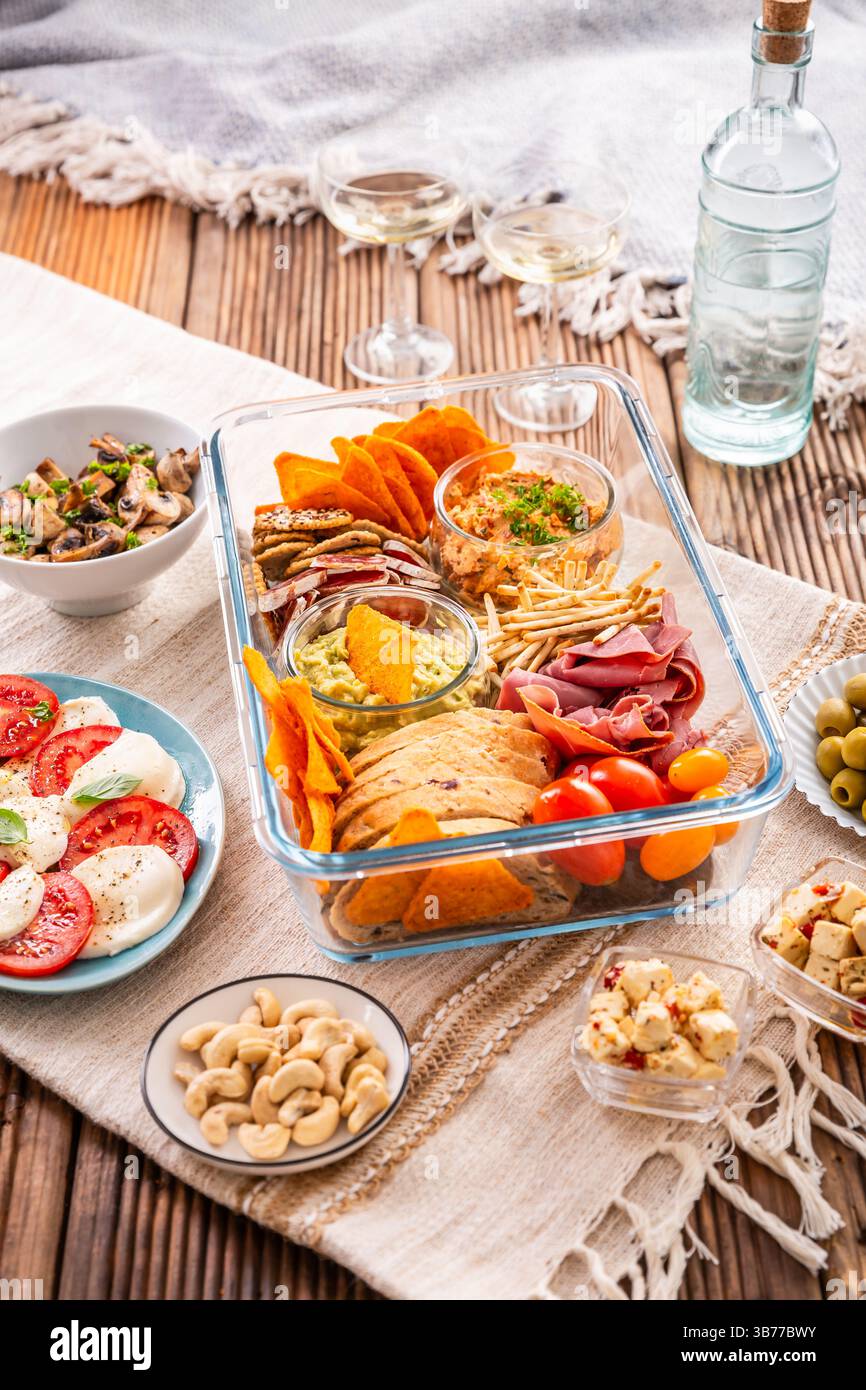 Vassoio con antipasti e vino per un picnic e per mangiare all'aperto Foto Stock