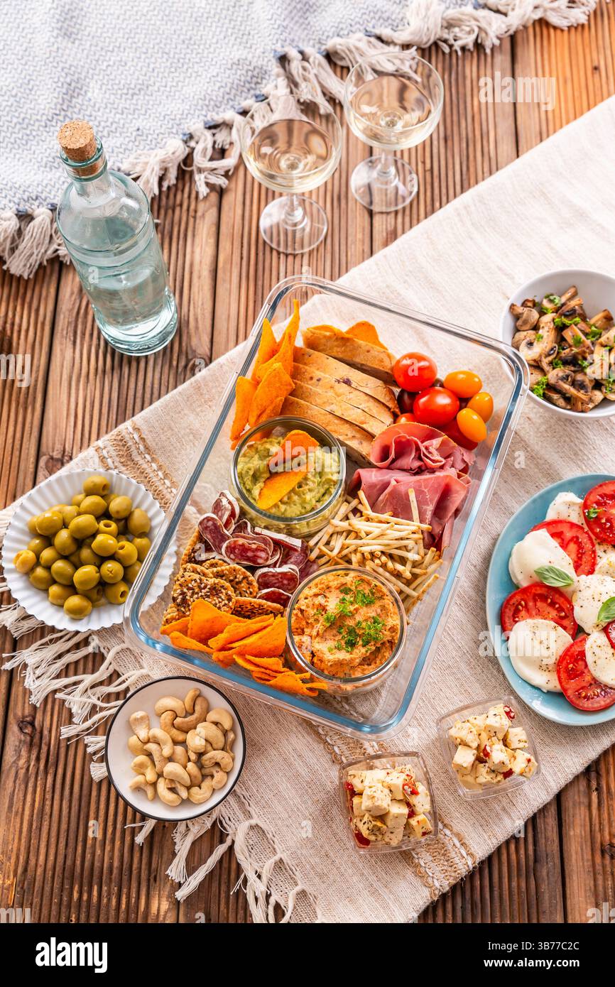 Vassoio con antipasti e vino per un picnic e per mangiare all'aperto Foto Stock