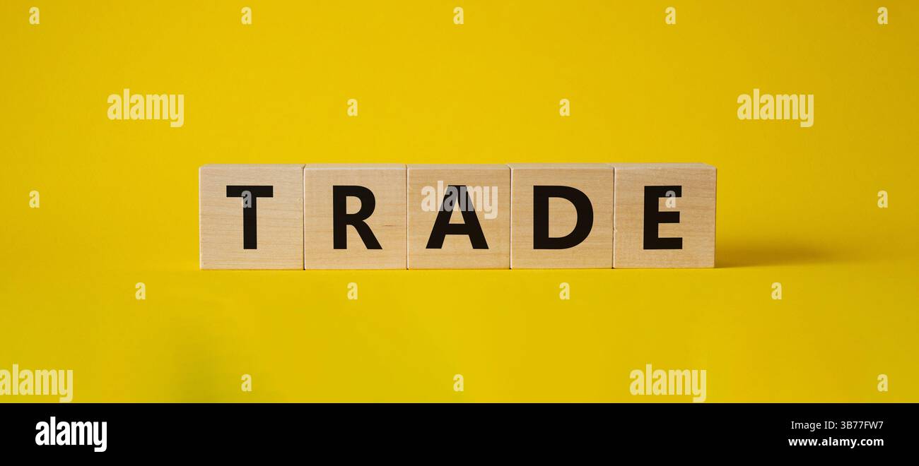Simbolo commerciale. Cubi di legno con Word Trade. Bellissimo sfondo giallo. Concetto commerciale. Copia spazio. Foto Stock