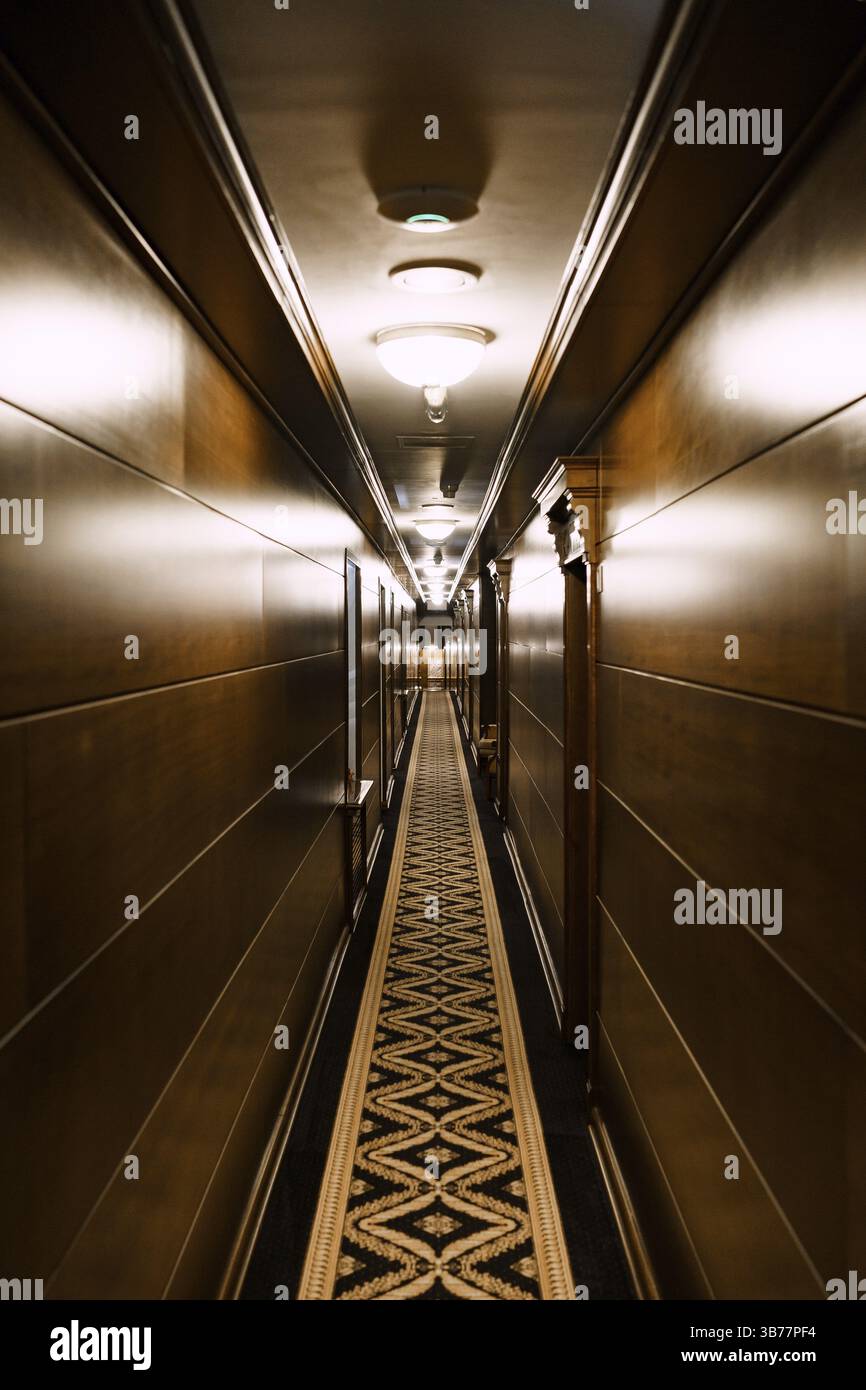 Cattaro, Montenegro - 21 MAGGIO 2018: Corridoio scuro dell'hotel. Un lungo tappeto con un motivo, rivestimento parete in legno. Corridoio dell'hotel deserto Foto Stock