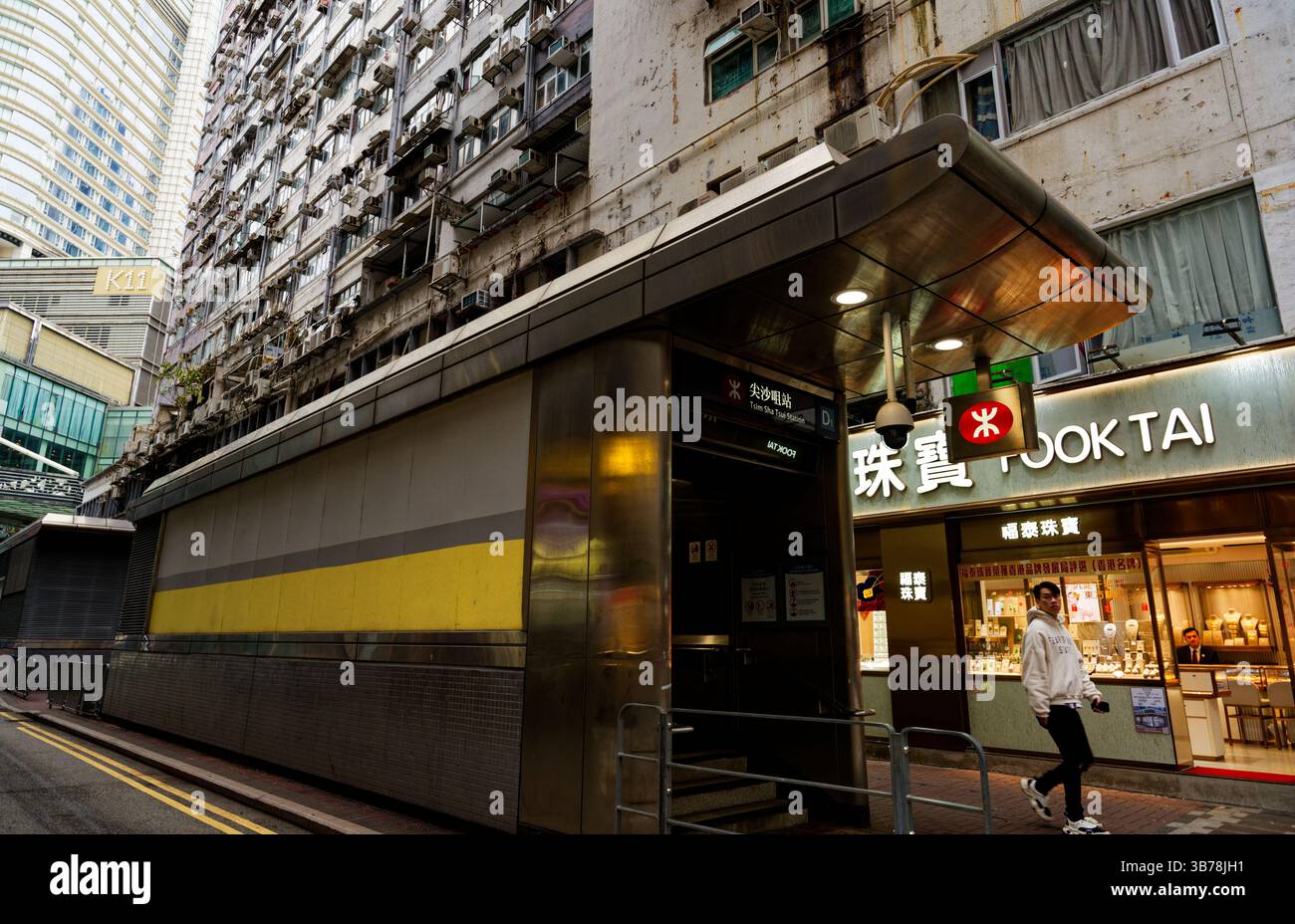 Un passante cammina oltre la struttura dell'uscita D della MTR di Tsim Sha Tsui Foto Stock