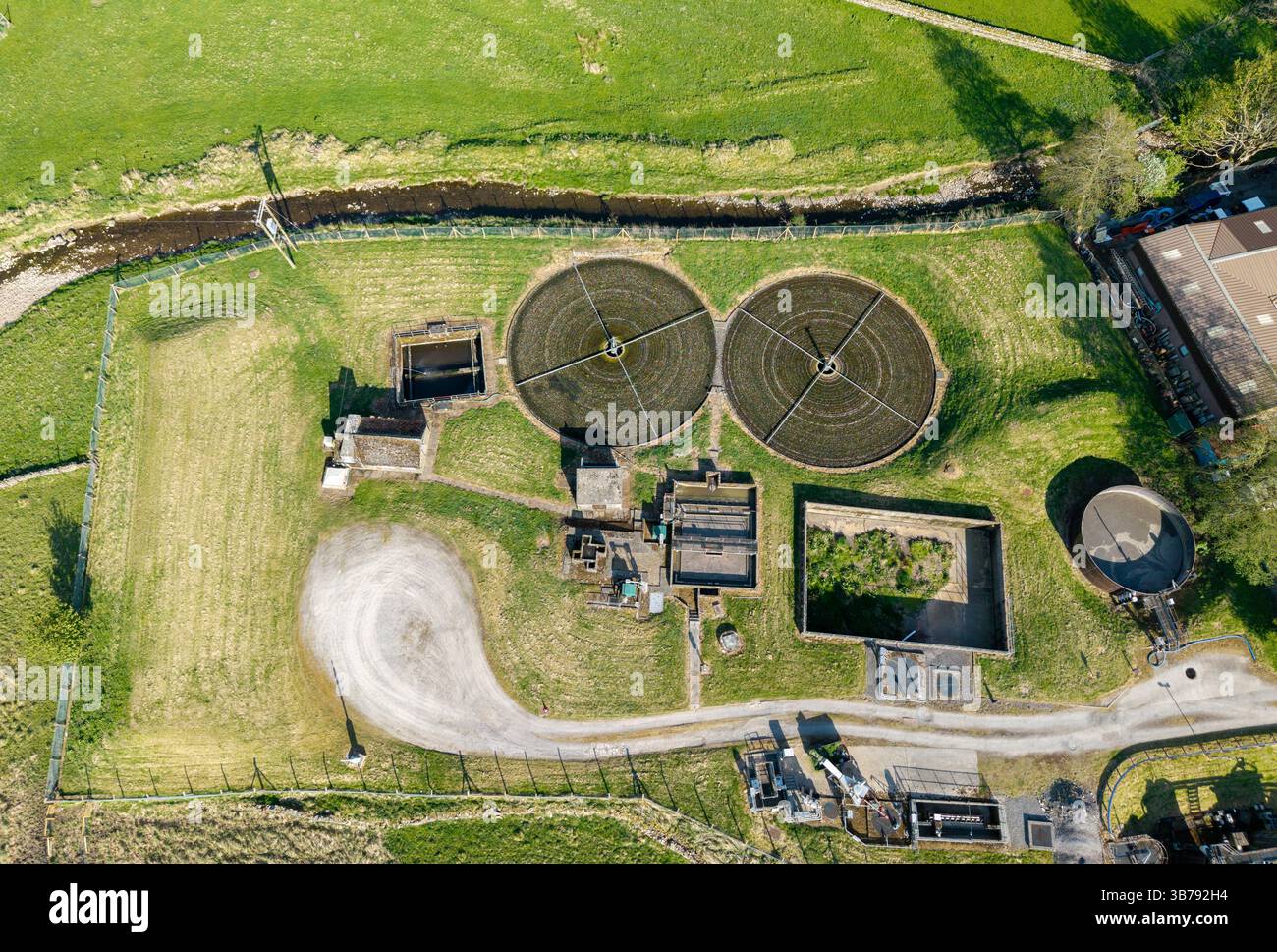 Il trattamento delle acque reflue si svolge lungo un fiume ai margini di una piccola città commerciale nel Yorkshire Dales National Park, Regno Unito. Foto Stock