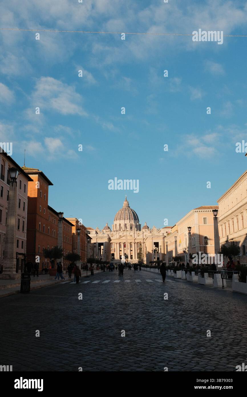 Vista mattutina della Basilica di San Pietro, città del Vaticano, con simmetrica architettura rinascimentale, con passeggiata turistica di fronte a un monumento storico religioso. Foto di alta qualità Foto Stock