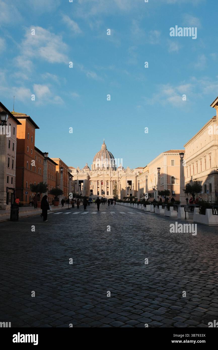 Vista mattutina della Basilica di San Pietro, città del Vaticano, con simmetrica architettura rinascimentale, con passeggiata turistica di fronte a un monumento storico religioso. Foto di alta qualità Foto Stock