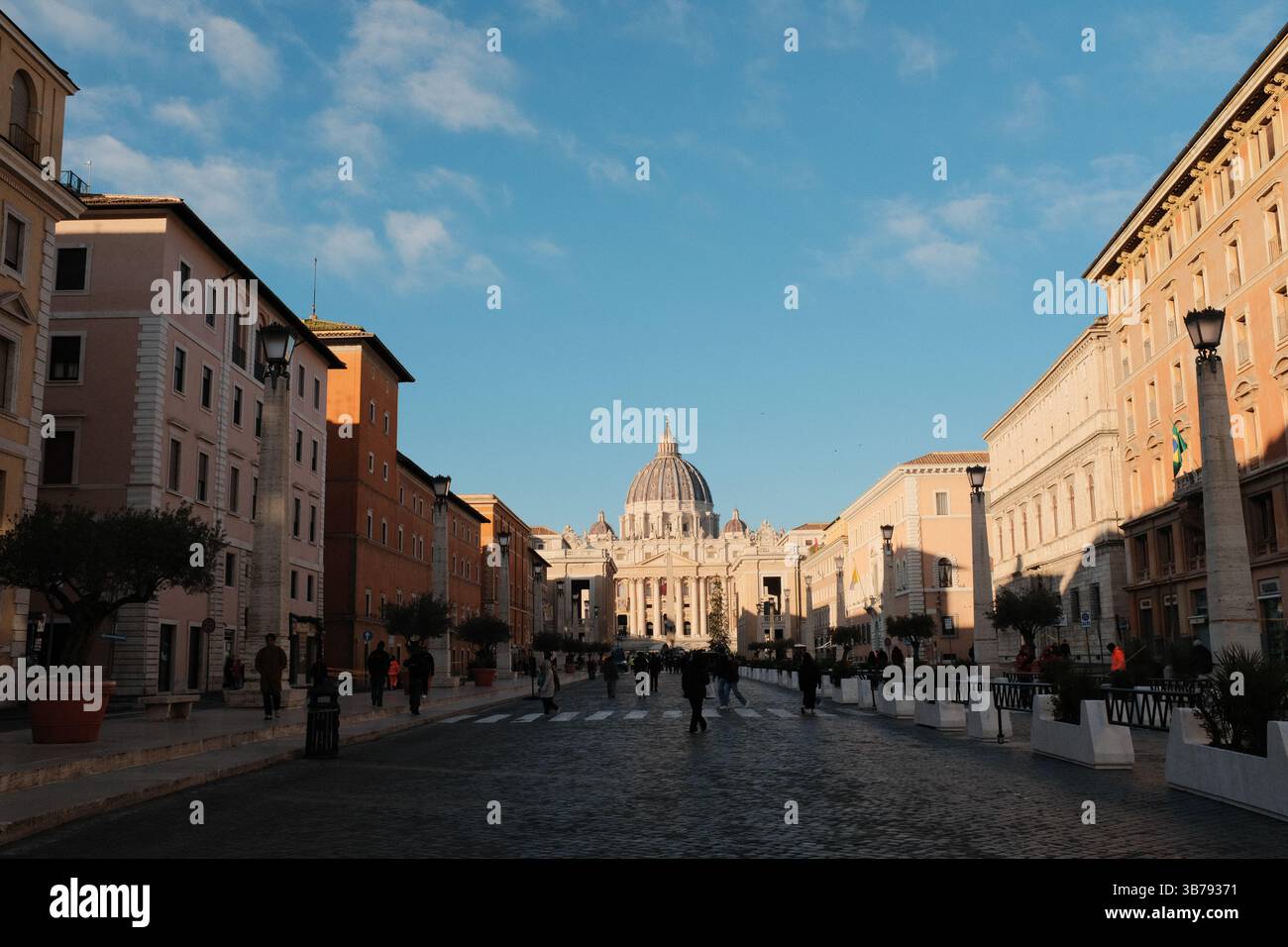 Vista mattutina della Basilica di San Pietro, città del Vaticano, con simmetrica architettura rinascimentale, con passeggiata turistica di fronte a un monumento storico religioso. Foto di alta qualità Foto Stock