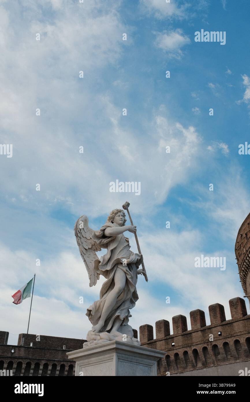 Statue d'angelo barocco sul Ponte Sant'Angelo a Roma con un cielo spettacolare e la classica architettura romana sullo sfondo, monumento culturale e dettagli scultorei. Foto di alta qualità Foto Stock