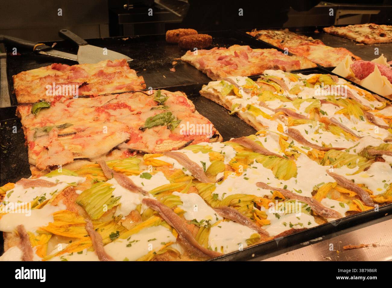 Autentico Street food italiano a Roma con pizza da asporto e bibita analcolica sul pavimento in pietra e bancone pizzeria pieno di condimenti cucina tradizionale Foto Stock