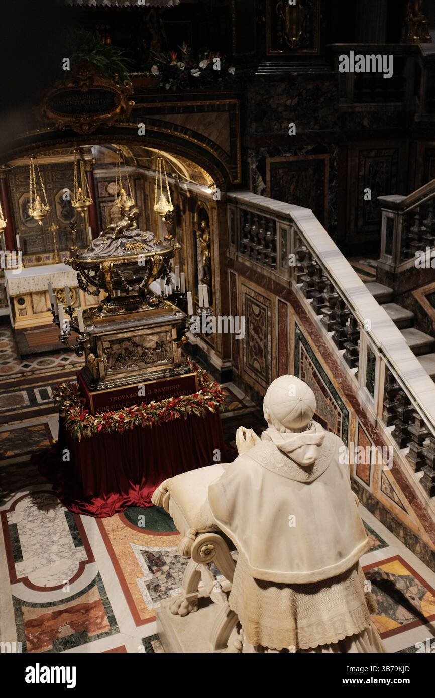 Cappella sopraelevata e tomba scultorea nella basilica di Santa Maria maggiore con ghirlande natalizie dettagliate opere d'arte murale e statue religiose sotto archi architettonici dipinti in oro. Foto di alta qualità Foto Stock