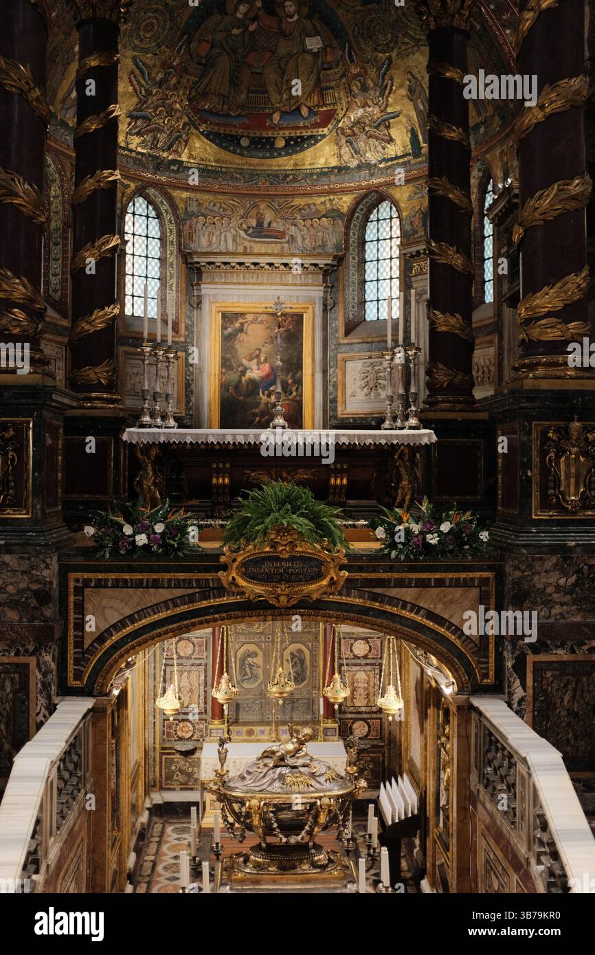 Cappella sopraelevata e tomba scultorea nella basilica di Santa Maria maggiore con ghirlande natalizie dettagliate opere d'arte murale e statue religiose sotto archi architettonici dipinti in oro. Foto di alta qualità Foto Stock