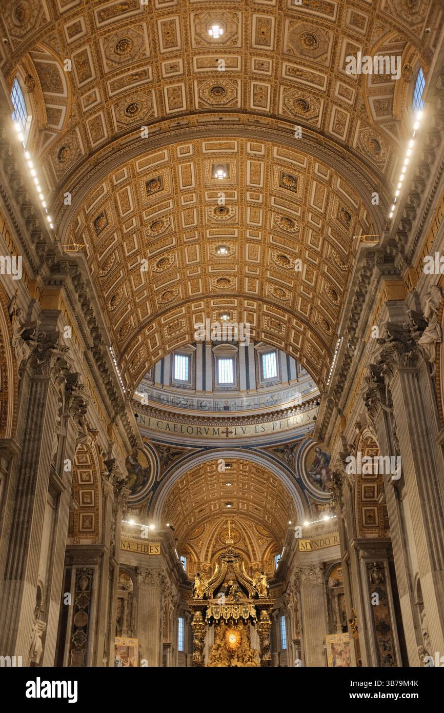 Navata centrale della Basilica di San Pietro decorata per Natale con soffitto a cassettoni dorati pavimenti in marmo e turisti che camminano verso l'altare papale nella città del Vaticano. Foto di alta qualità Foto Stock