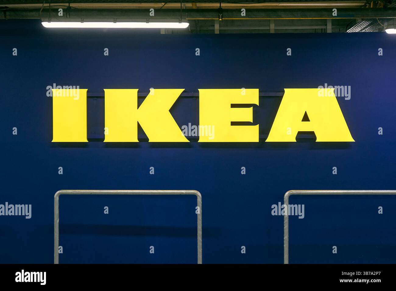Cartello giallo del negozio Ikea sul muro blu nel parcheggio Foto Stock