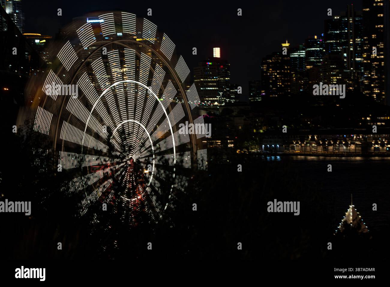 Vista notturna con otturatore lento della ruota panoramica in movimento al Sydney Luna Park Foto Stock