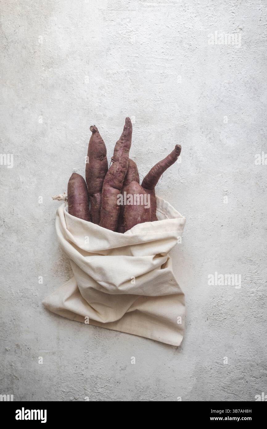 Patate dolci viola in un sacchetto di iuta Foto Stock