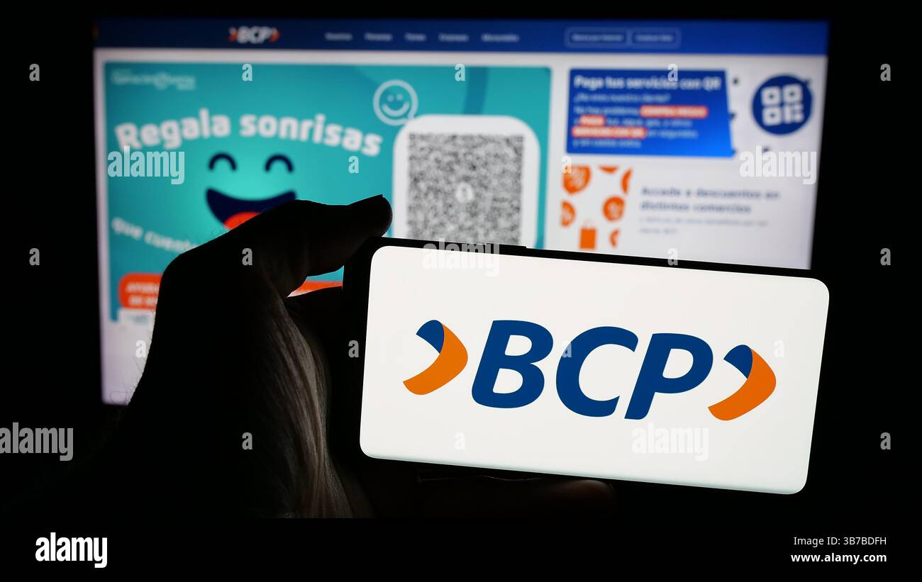In questa immagine, una persona ha un telefono cellulare con il logo del Banco de credito de Bolivia S.A. (BCP) sullo schermo davanti alla pagina web. Foto Stock