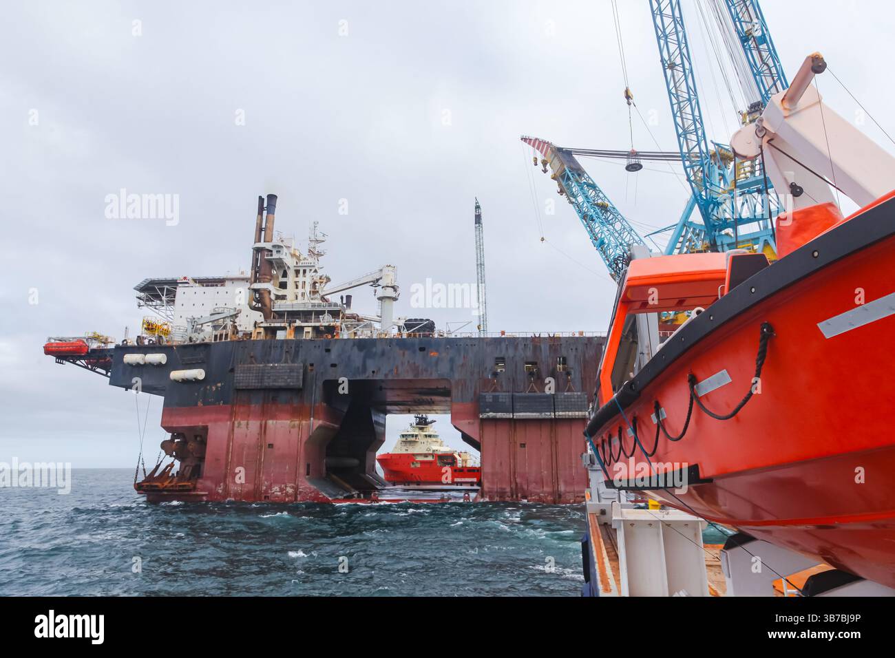 Una piattaforma petrolifera offshore servita da navi di rifornimento offshore. Foto Stock